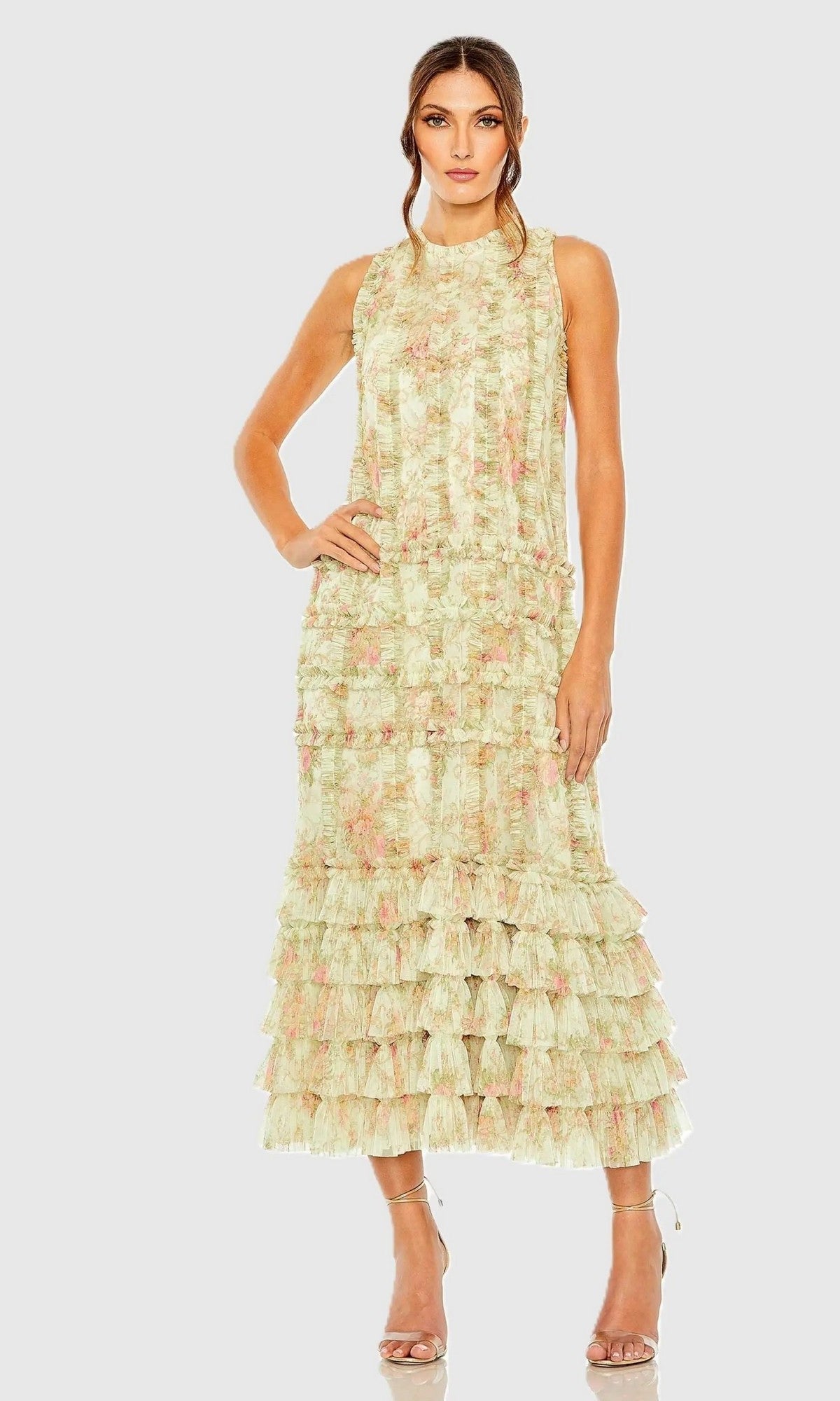 Woman in the Sage Multi Mac Duggal 8484 Midi Party Dress, featuring a sleeveless floral design and tiered ruffles, stands with one hand on her hip against a plain light background.